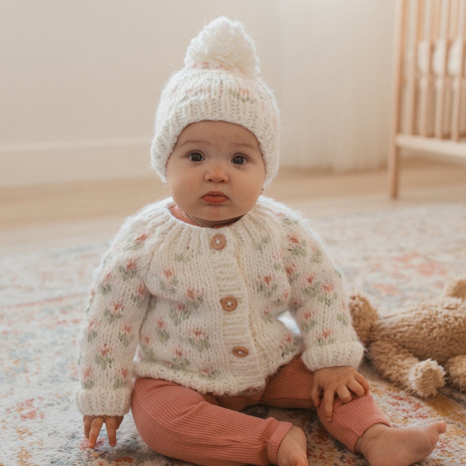 Baby wearing Bitty Blooms white floral cardigan sweate